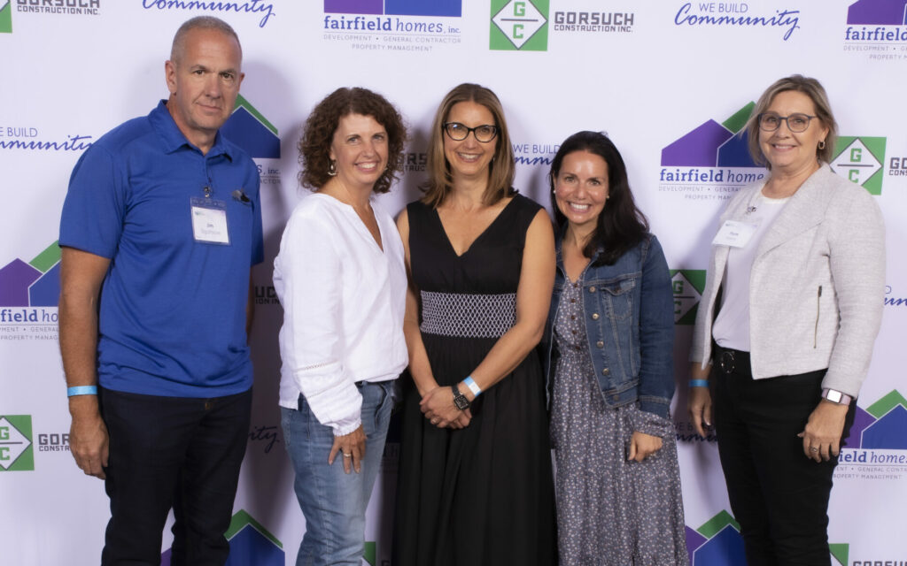 Fairfield Homes employees near logo wall